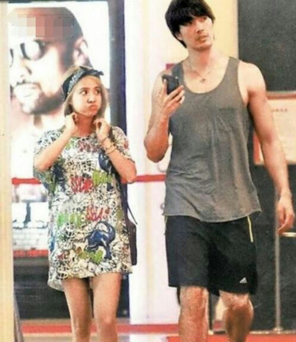 people-A-woman with blonde hair and a bandana wearing a patterned dress-A-man with dark hair wearing a grey tank top and black shorts-A-celebrity spotting-A-paparazzi photo