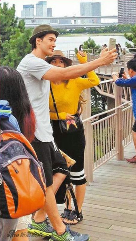 people-Takeshi Kaneshiro-A-selfie-A-yellow sweater-B-bucket hat-C-outdoor boardwalk