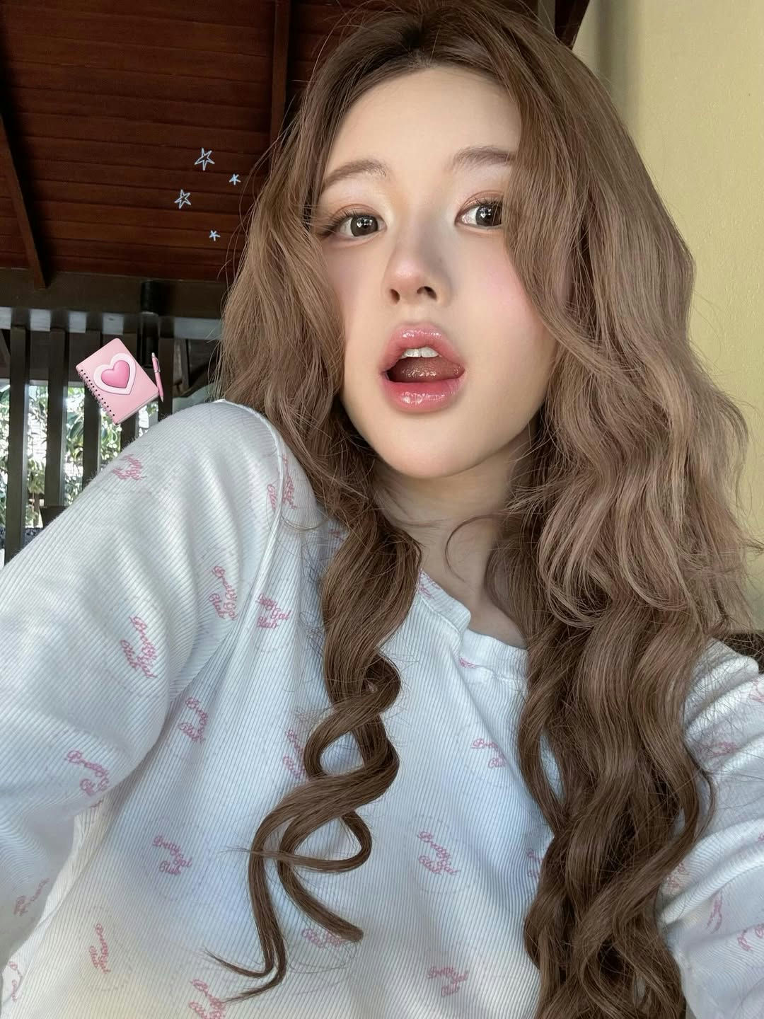 people-Asian female-tongue out pose-long wavy brown hair-pink patterned shirt
