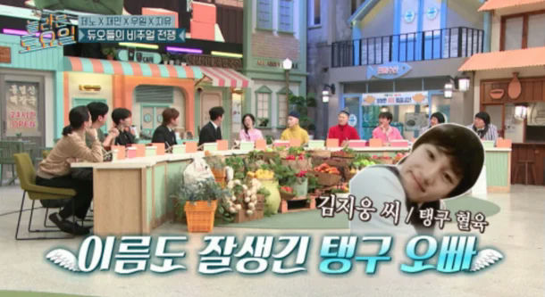 people-Kim Ji-woong-Korean-variety-show-set-Korean-text-overlay-A-handsome-man-in-foreground-A-group-of-people-seated-at-table-in-background