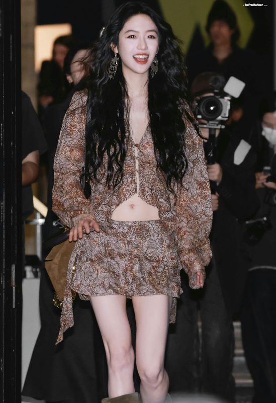 people-Kim Go Eun-brown patterned two-piece outfit-black long wavy hair-large ornate earrings-smiling outdoors-photographers in background