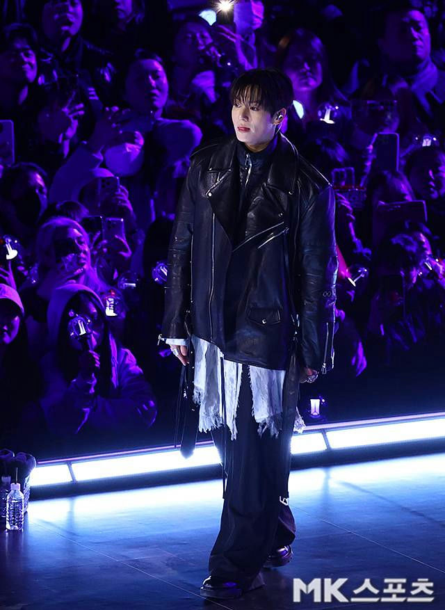 people-Jungkook (BTS)-black leather jacket-audience with phones-stage lighting