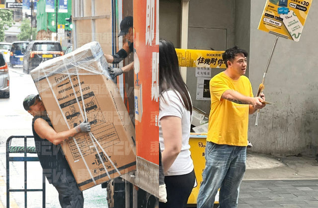 people-man in yellow shirt-holding advertising sign-moving refrigerator-street scene