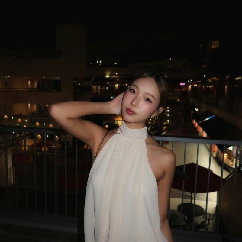 people-Asian woman-nighttime-balcony-halter top-gold jewelry-looking at camera
