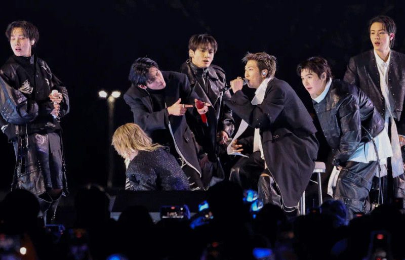 people-BTS-performance-on-stage-dark-outfits-audience-holding-phones