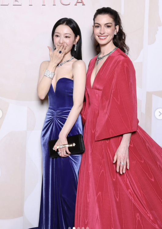 people-Anne Hathaway and Ni Ni-smiling-strapless blue velvet dress-deep V-neck red dress-jewelry-clutch