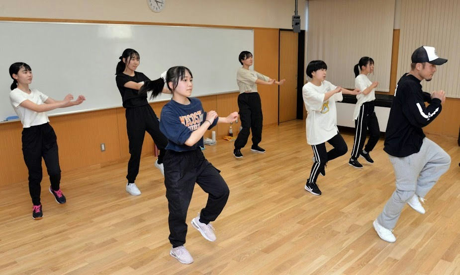people-Group of young dancers-A-hip hop class-A-studio practice-B-instructor and students-C-energetic movement