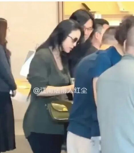 people-Zhang Ziyi-dark sunglasses-green cardigan-dark hair-crowd