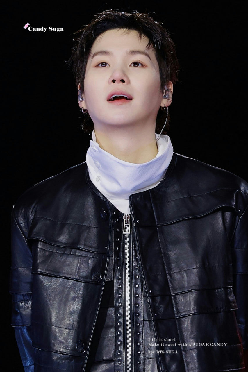 people-Suga (Min Yoongi) of BTS-Close-up performance shot-Black leather jacket-White turtleneck-Dark background
