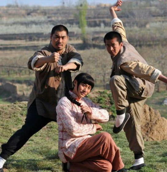 people-Three men in martial arts poses-A-Kung Fu-A-Outdoor setting-A-Chinese clothing-B-Braided hair-C-Tiger stance-C-Crane stance
