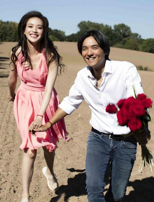 people-Shu Qi and Feng Delun-running hand-in-hand-holding red roses-outdoor field setting