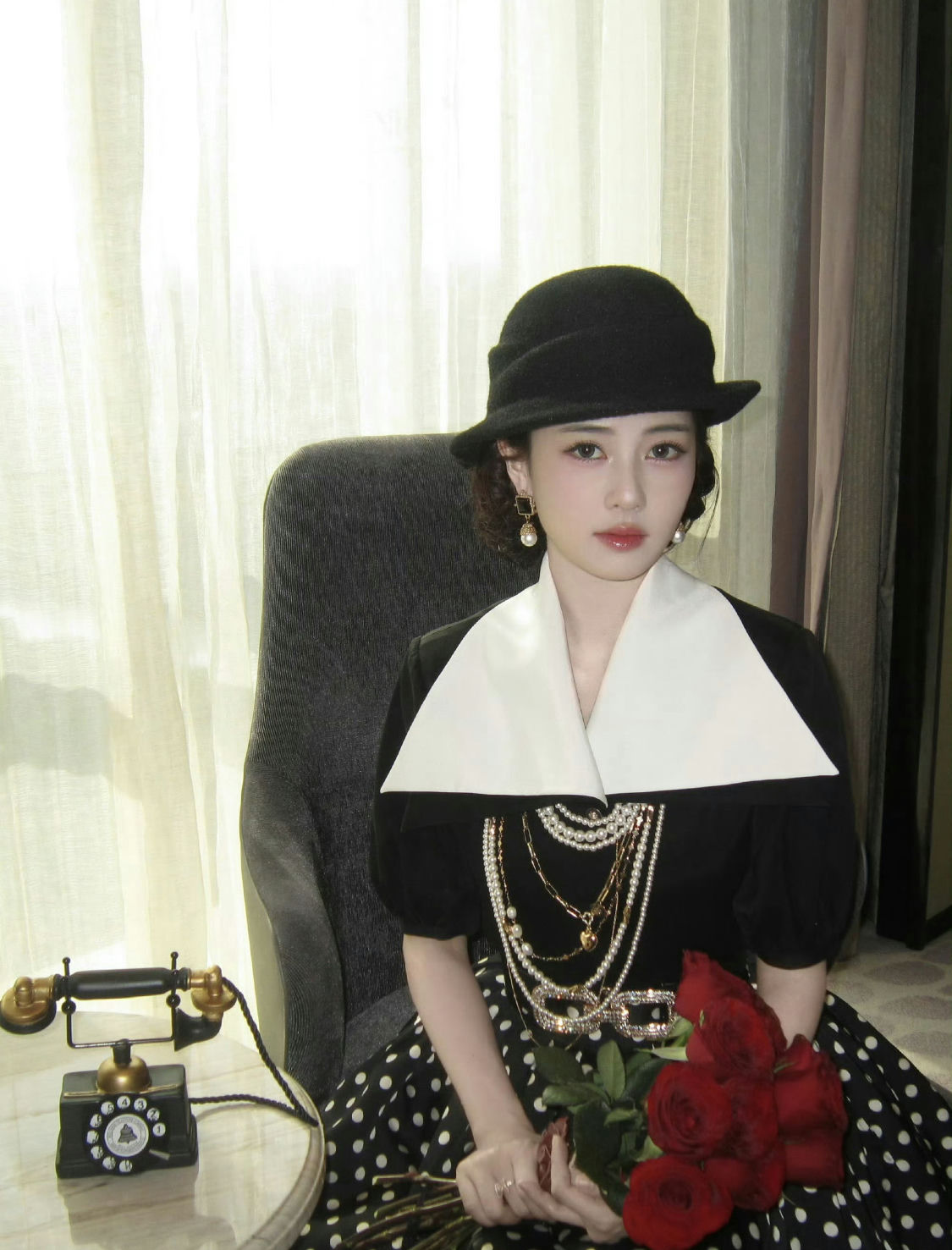 people-A-woman-A-vintage style-A-black hat-A-pearl necklaces-A-polka dot skirt-A-red roses
