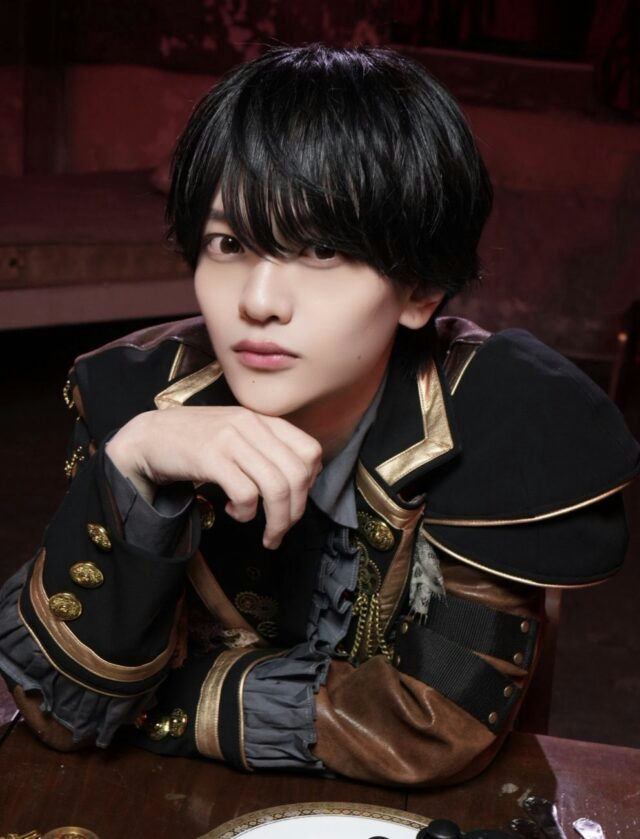 people-Kenta Izuka-actor-A-Japanese stage actor-A-theatrical costume-B-black and gold uniform-B-leaning on hand-C-dark lighting