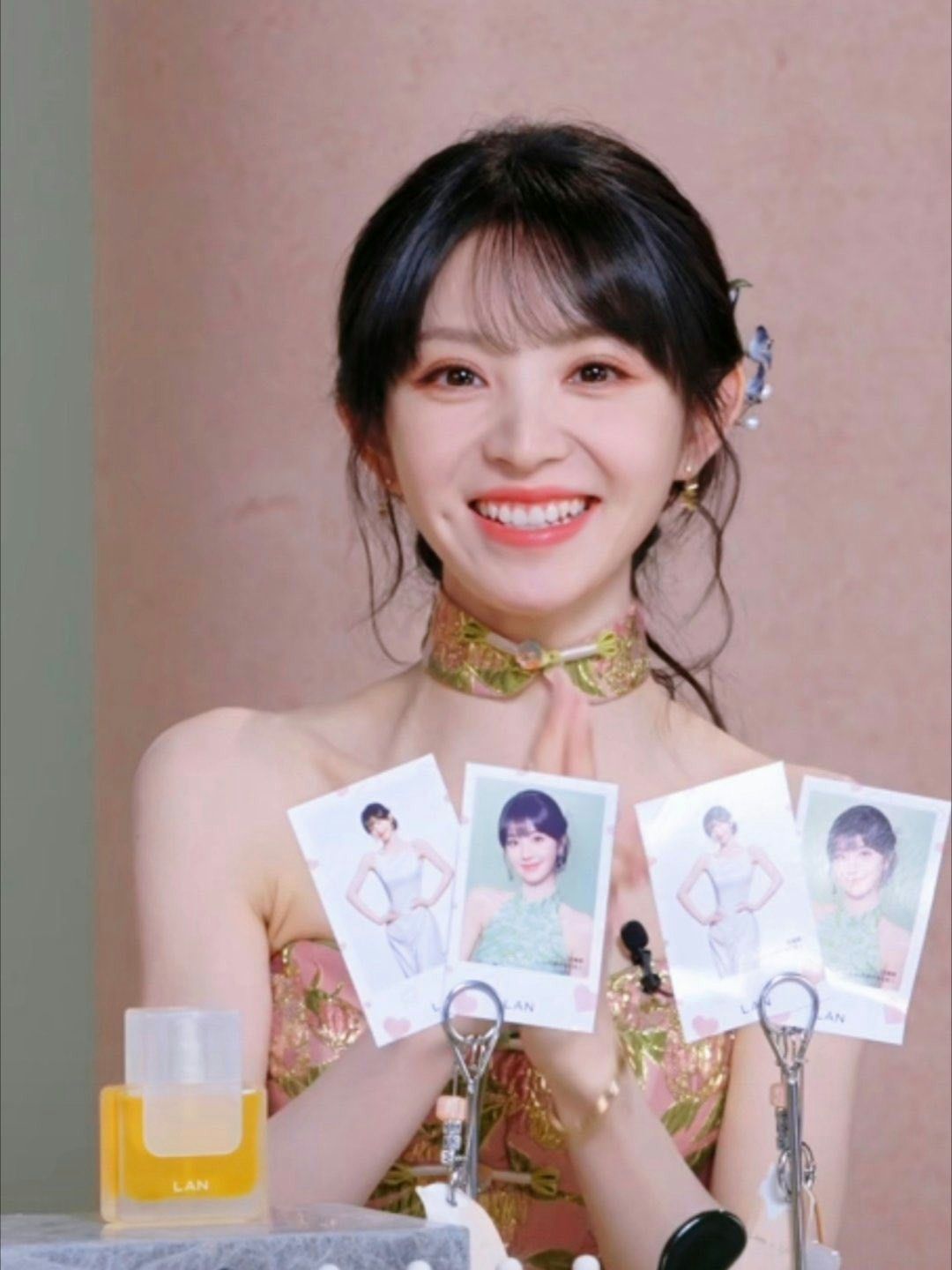 people-Cheng Xiao-smiling-A-holding photos-B-wearing traditional dress-C-dimples