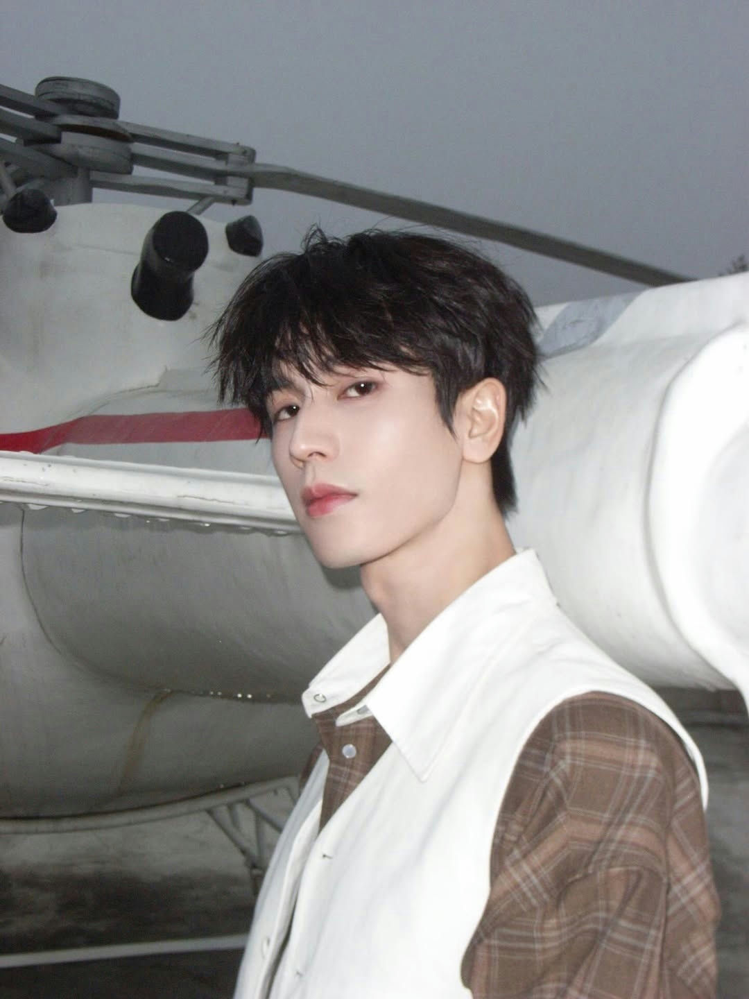 people-Asian male-dark hair-plaid shirt-white vest-aircraft background